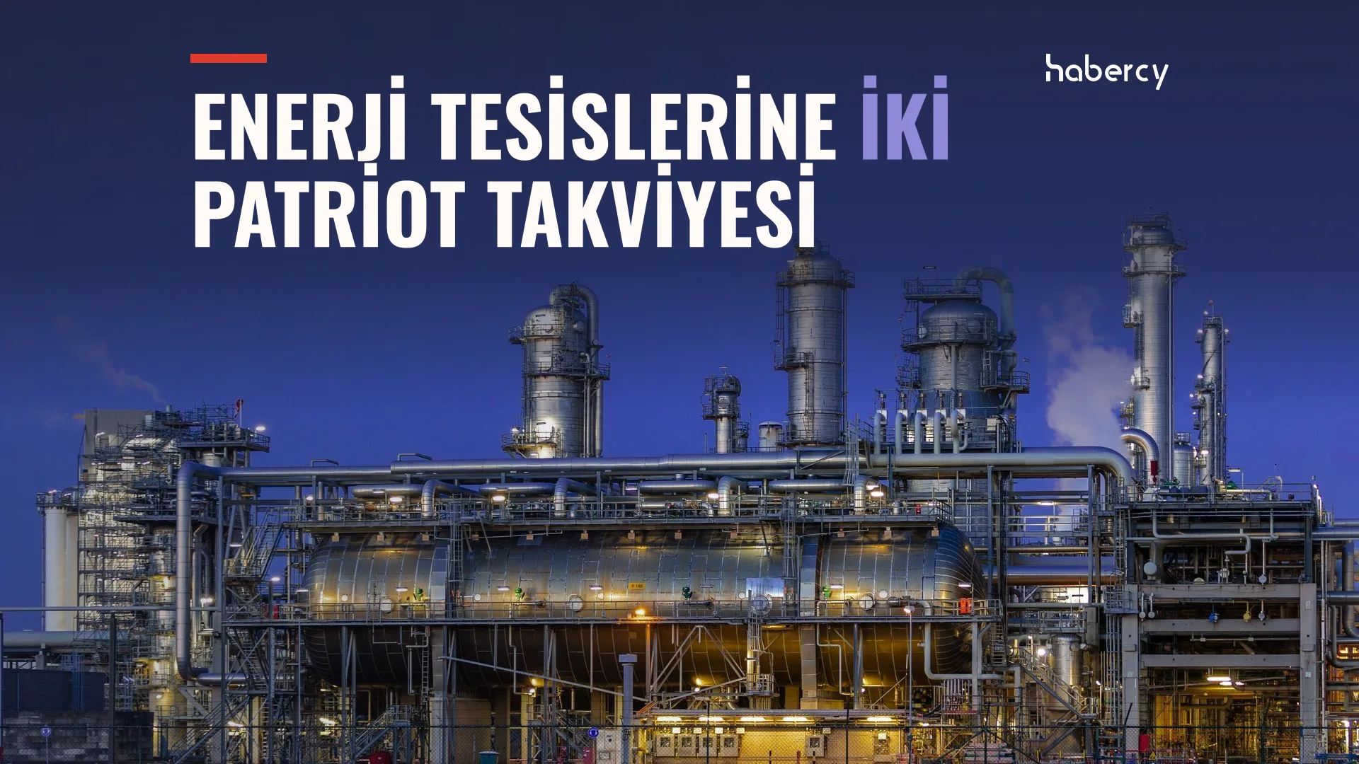 Gece ışıklandırılmış büyük bir petrol rafinerisi, kuleler ve boru hatları