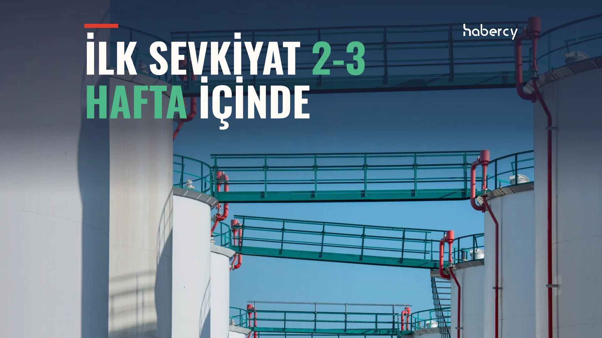 Yeşil metal geçitlerle birbirine bağlı beyaz depolama tankları