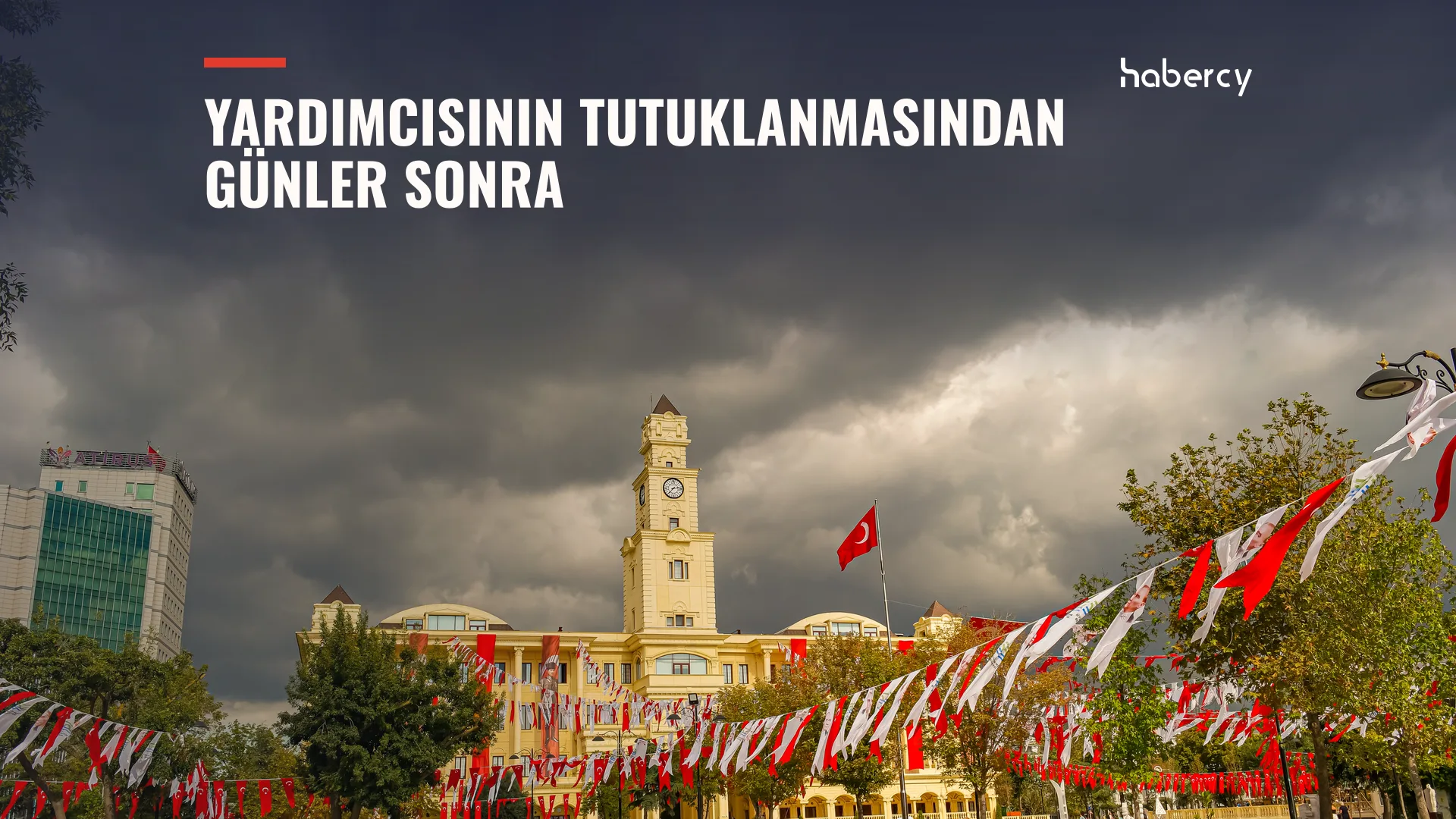 Bulutlu gökyüzü altında saat kuleli sarı bina, Türk bayrağı ve süsleme flamaları