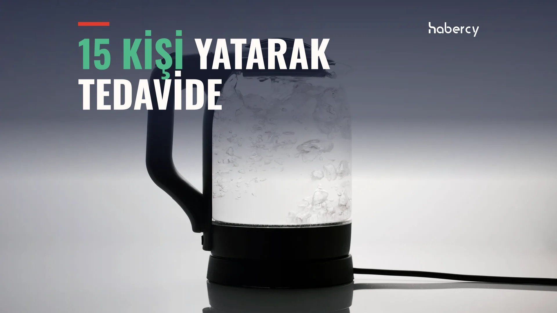 Koyu arka plan önünde içinde kaynayan su olan cam elektrikli su ısıtıcısı