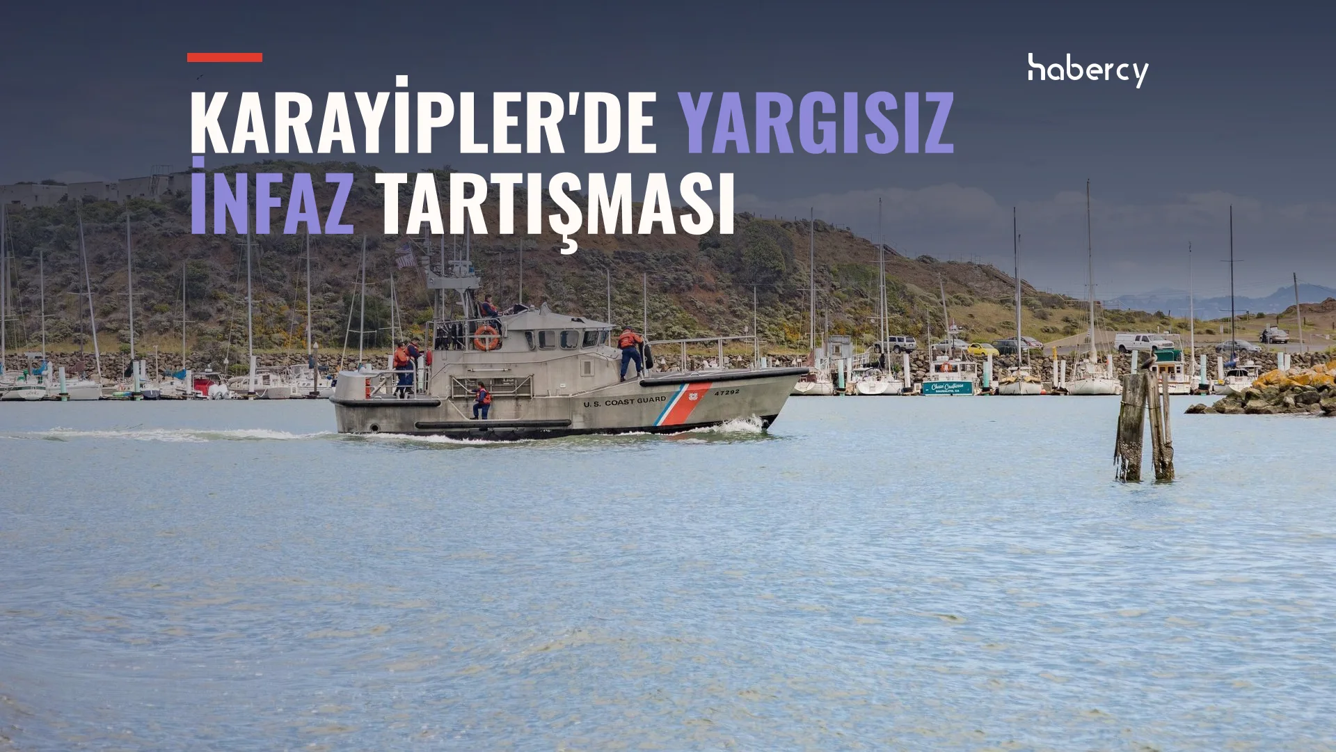 Limanda ilerleyen, turuncu şeritli bir sahil güvenlik botu, arkada yelkenliler