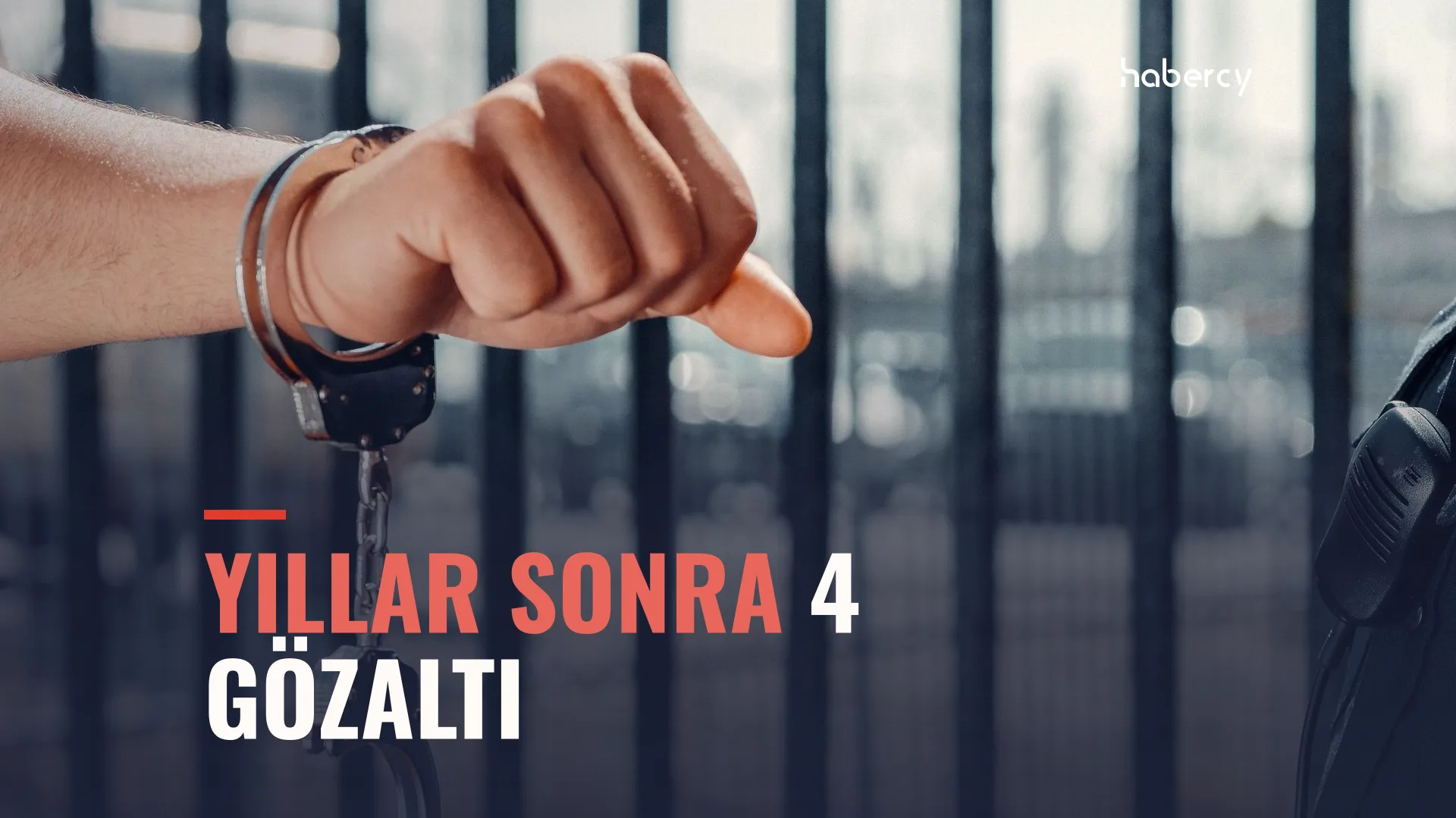 Kelepçeli bir bilek, arka planda demir parmaklıklar ve bulanık bir polis silueti