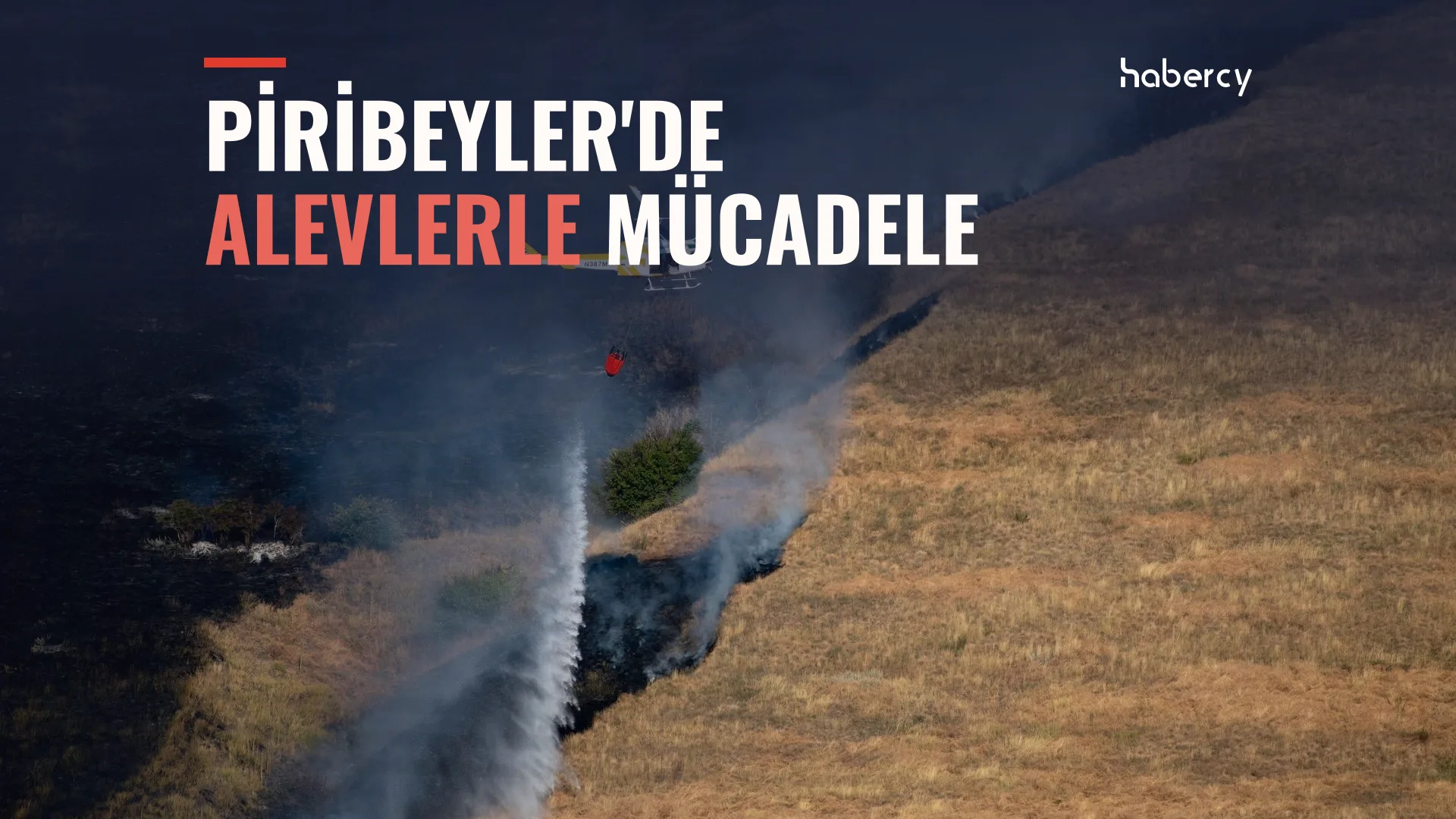 Helikopter, kuru otlarla kaplı yanık bir yamaca su bırakıyor; arazinin bir bölümü kararmış, duman yükseliyor.